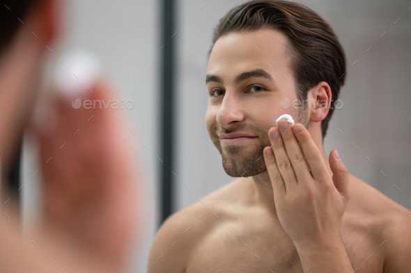 Half Naked Man Standing Near At The Mirror And Applying Shaving Foam On